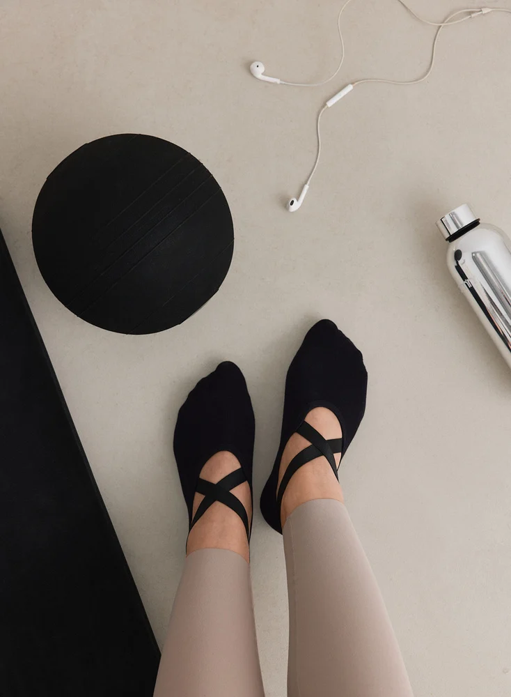 Zwarte Aim'n pilates sokken met witte logo en anti-slip zool