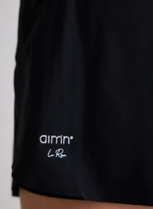 Detail van het aim'n logo en de ademende stof van de zwarte running shorts