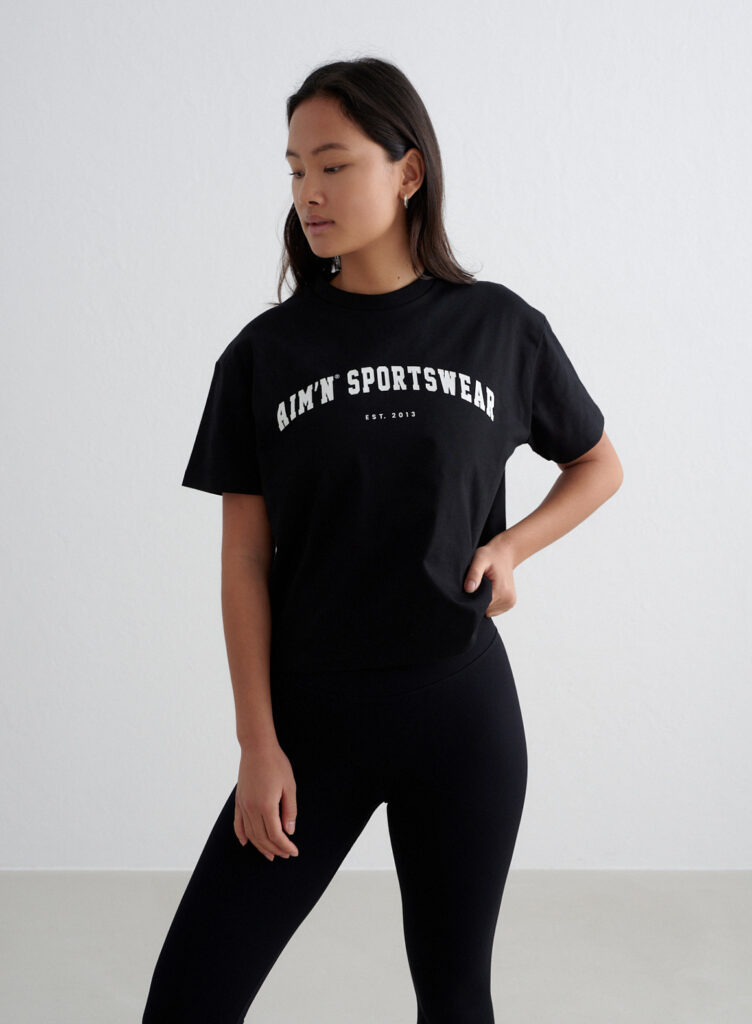 Aim'n Black Varsity Boxy T-shirt 24080607-010 dames shirt in het zwart met Varsity logo en boxy pasvorm