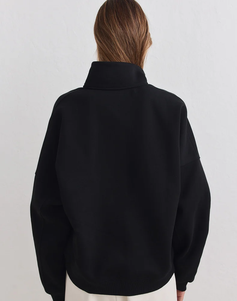 Aim'n Black Varsity Sweat Half Zip 23100184-010 dames sweater in het zwart met halve ritssluiting en Varsity logo