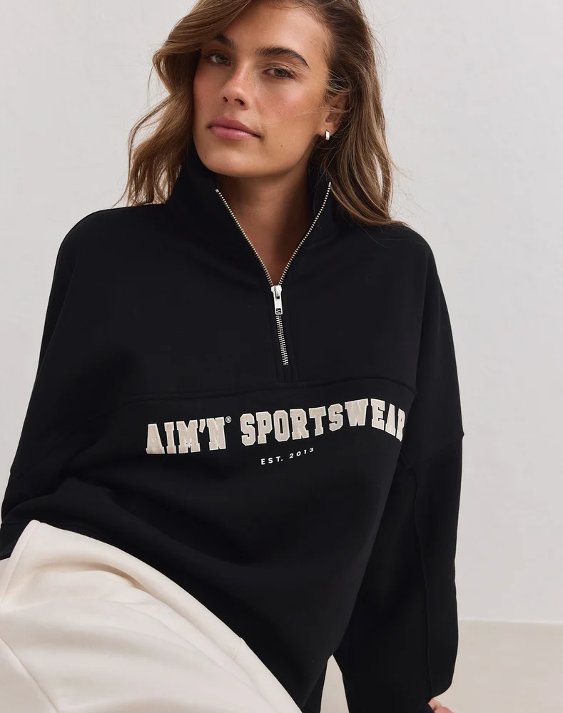 Aim'n Black Varsity Sweat Half Zip 23100184-010 dames sweater in het zwart met halve ritssluiting en Varsity logo